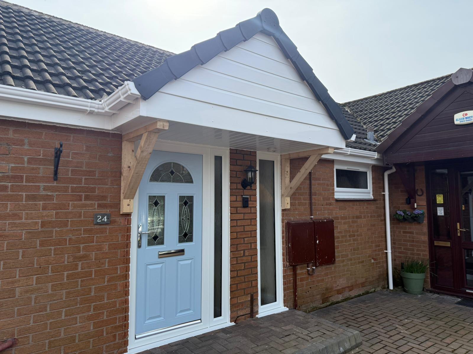 Pale blue composite door under a new porch canopy